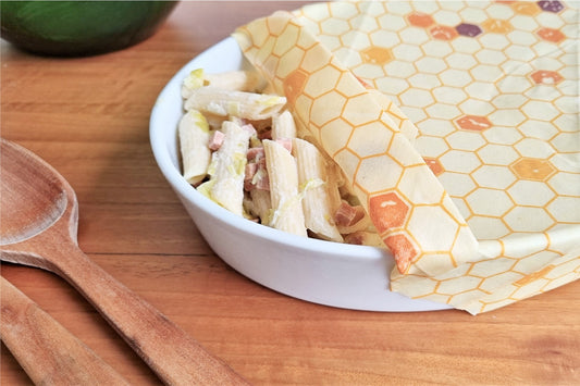 beeswax wrap being used on a container with pasta